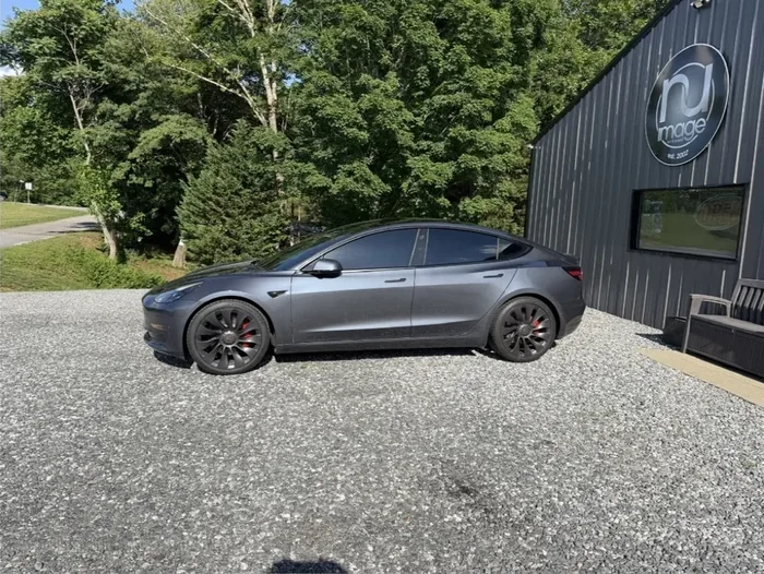 Gray Tesla Model 3 with tinted windows at the NU-Image shop
