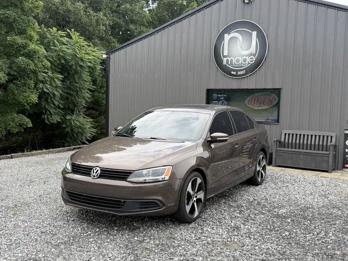 Brown Volkswagen Jetta at three-quarter front angle with tinted glass